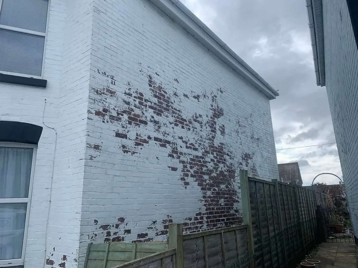 Peeling paint on a brick wall before redecoration in St Just